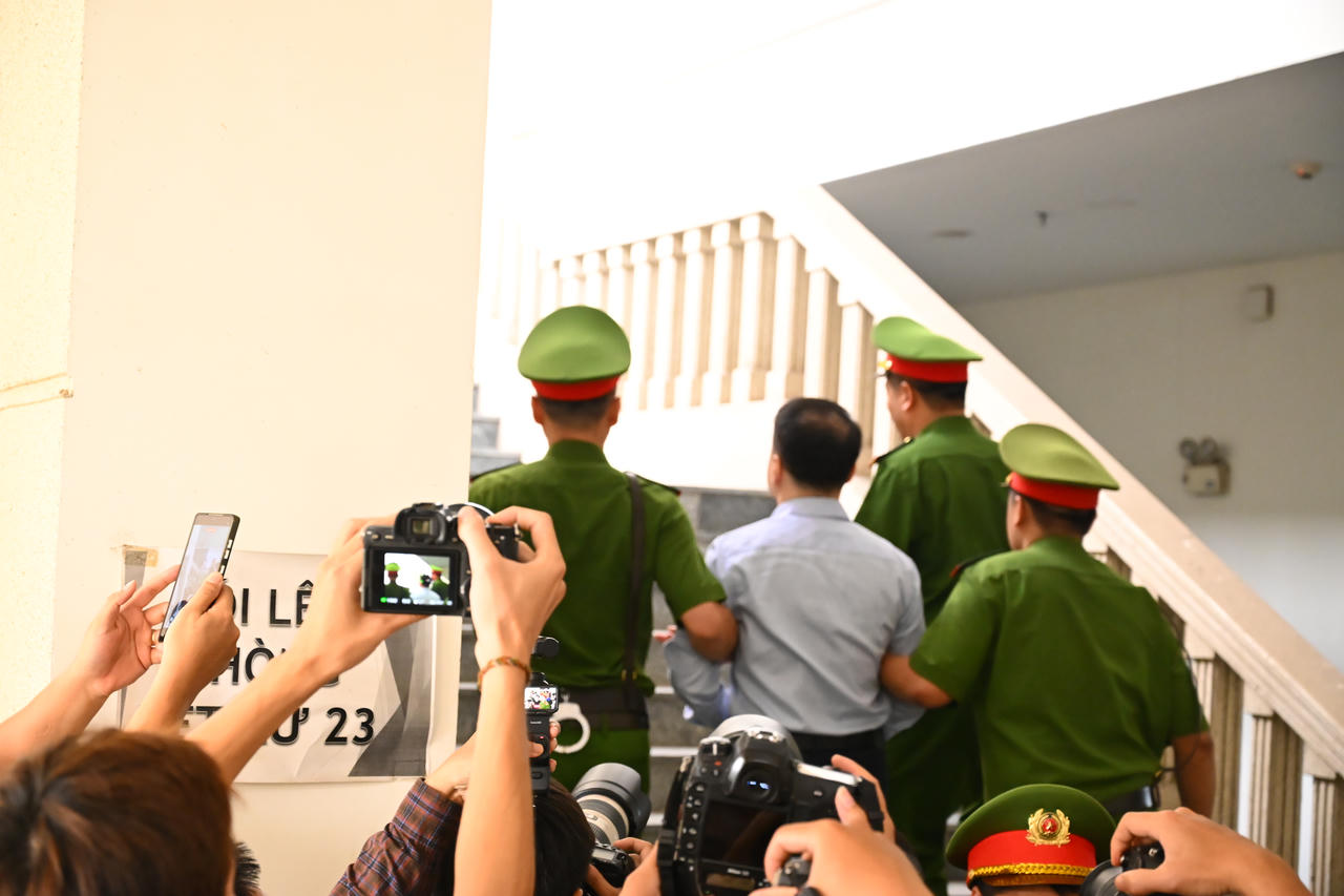 Dẫn giải bị cáo Nguyễn Hoà Bình đến phiên toà. (Ảnh: Duy Cảnh)