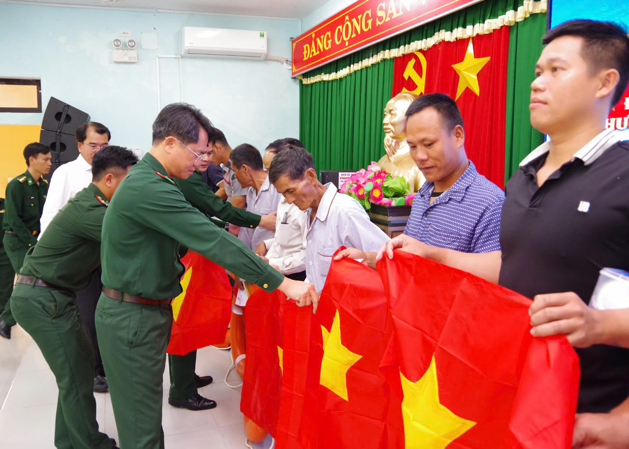 Tặng cờ Tổ quốc cho ngư dân xã Phú Vinh. (Ảnh: H.Minh)