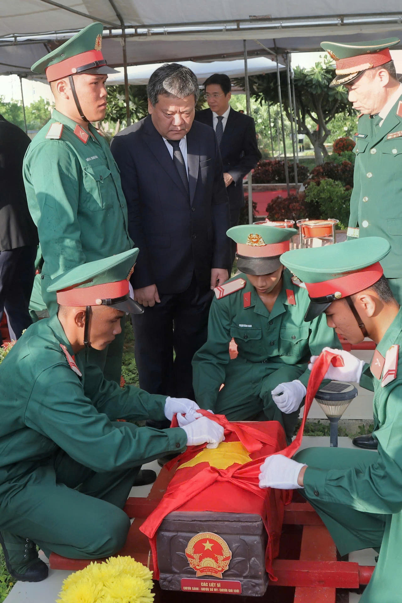 Bí thư Tỉnh ủy Khánh Hòa Trần Phong cùng lực lượng tiêu binh di chuyển các hài cốt liệt sĩ đến ô mộ để an táng. Ảnh: Mai Đông.