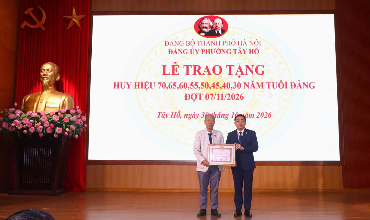 Trưởng Ban Xây dựng Đảng phường Tây Hồ Nguyễn Mạnh Tiến trao Huy hiệu cho các Đảng viên (Ảnh: T.Trang).