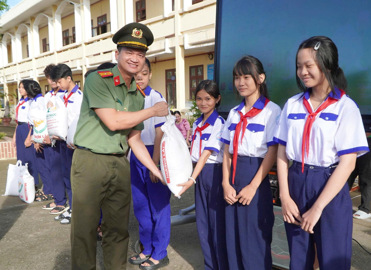 Cán bộ Phòng An ninh mạng trao quà cho học sinh có hoàn cảnh khó khăn trong các hoạt động hưởng ứng chiến dịch (Ảnh: H.Đ).