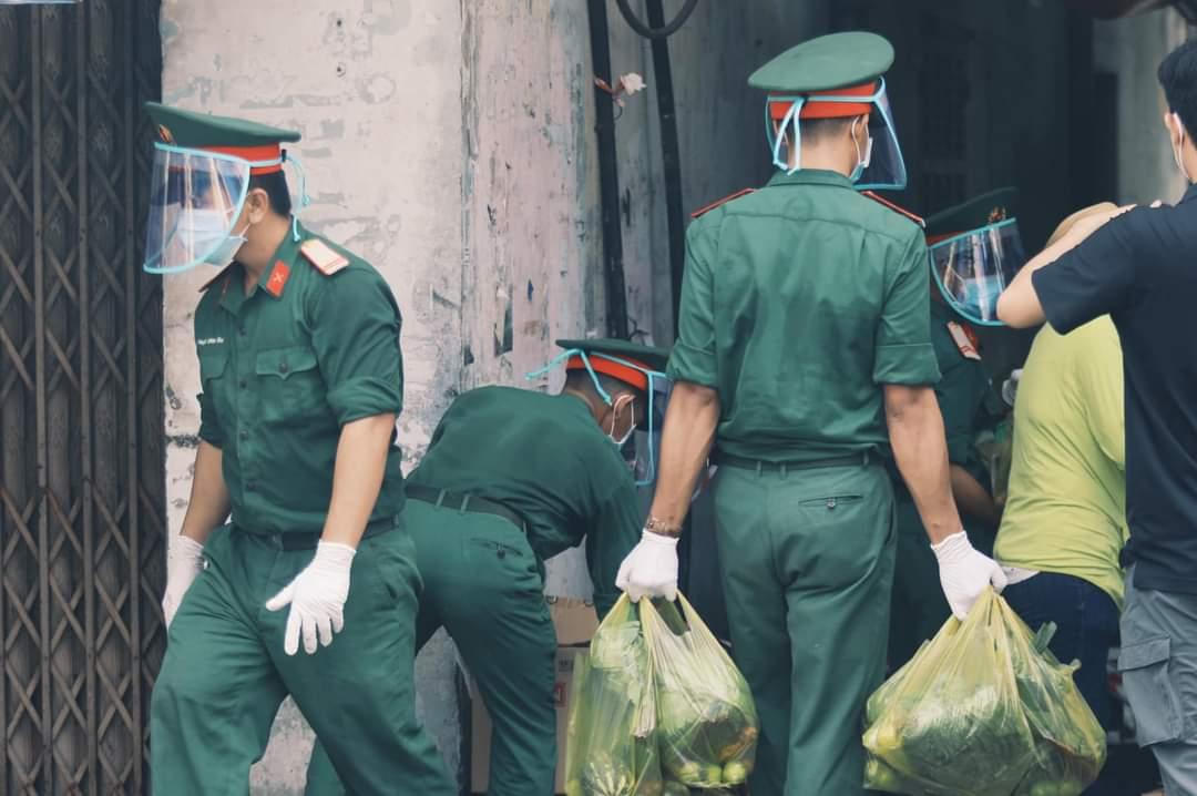 Các chiến sĩ quân đội hỗ trợ đưa lương thực, thực phẩm đến từng nhà người dân