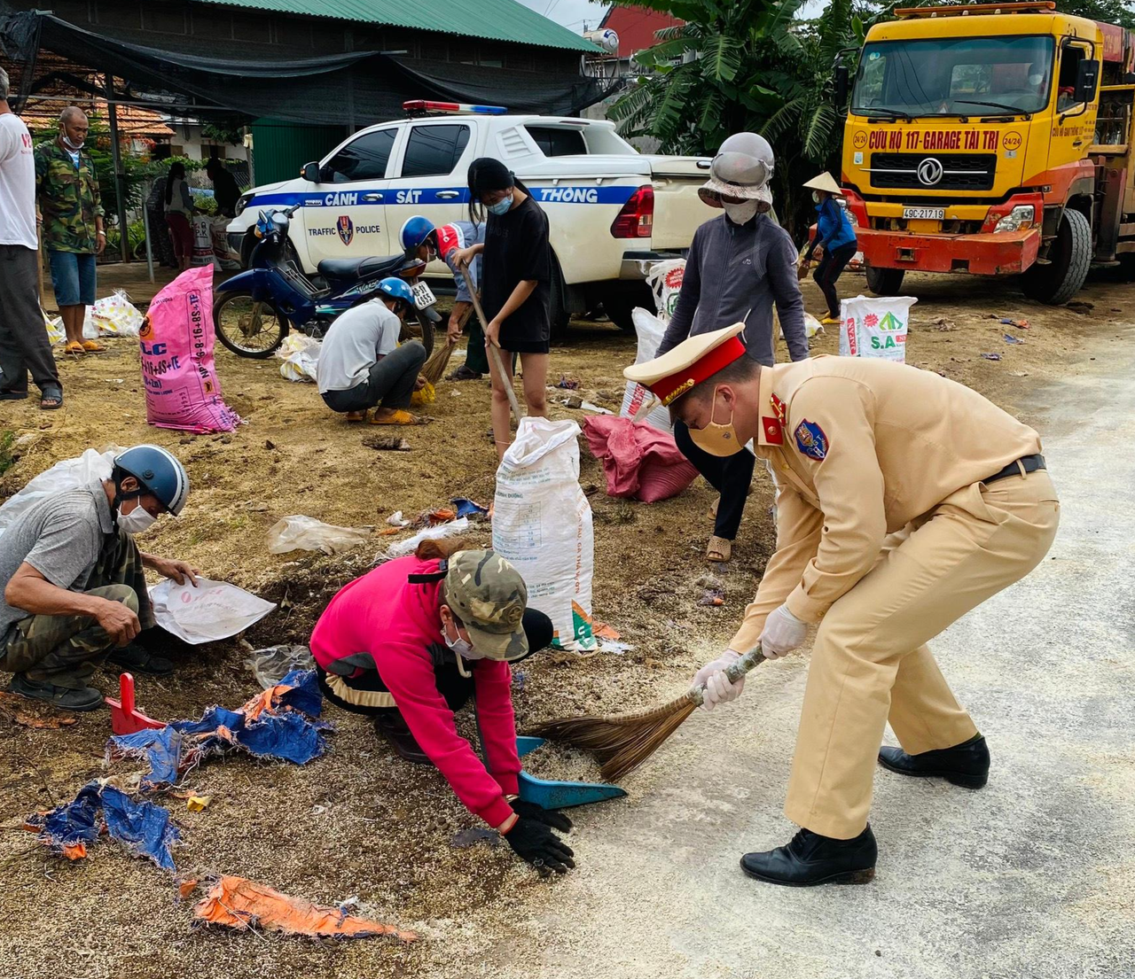 Cảnh sát giao thông thu dọn phân bón giúp tài xế gặp nạn