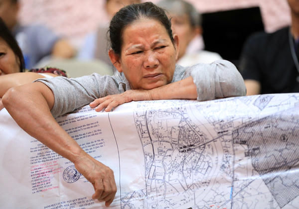 Người dân Thủ Thiêm mang bản đồ quy hoạch đến buổi làm việc. Ảnh: Hữu Khoa.