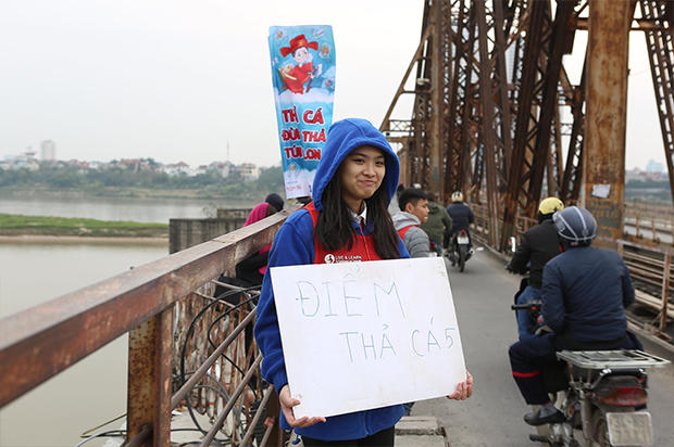 Nhiều tình nguyện viên hướng dẫn người dân thả cá chép tiễn ông Táo