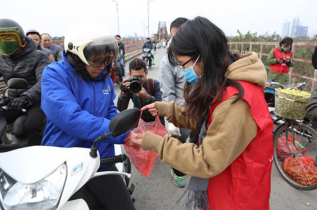 Nhiều tình nguyện viên hướng dẫn người dân thả cá chép tiễn ông Táo