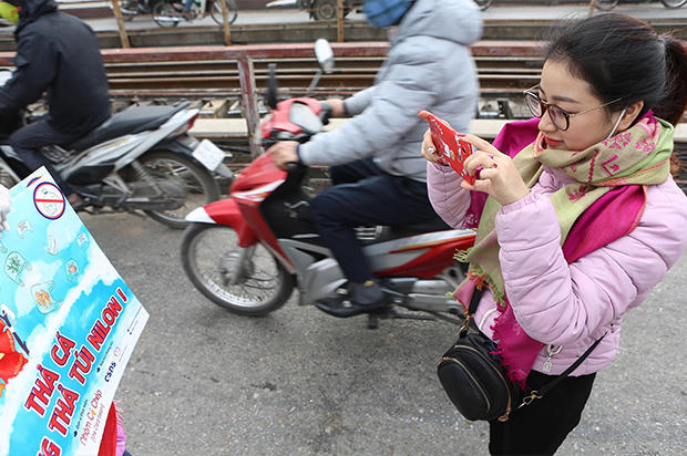 Nhiều tình nguyện viên hướng dẫn người dân thả cá chép tiễn ông Táo