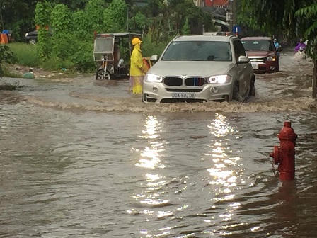 Ô tô, xe máy dò dẫm đi trên nước ở Hà Nội trong mưa bão