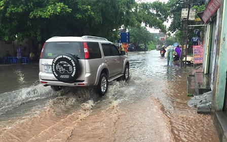 Ô tô, xe máy dò dẫm đi trên nước ở Hà Nội trong mưa bão