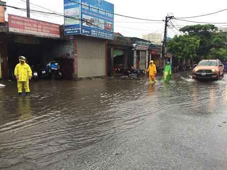 Ô tô, xe máy dò dẫm đi trên nước ở Hà Nội trong mưa bão