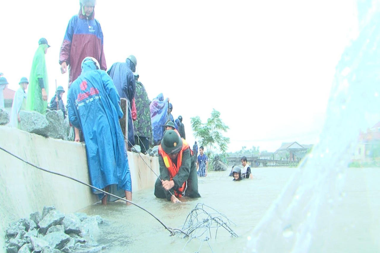 Bộ đội, dân quân đắp đê chống sạt lở tại huyện Quảng Điền