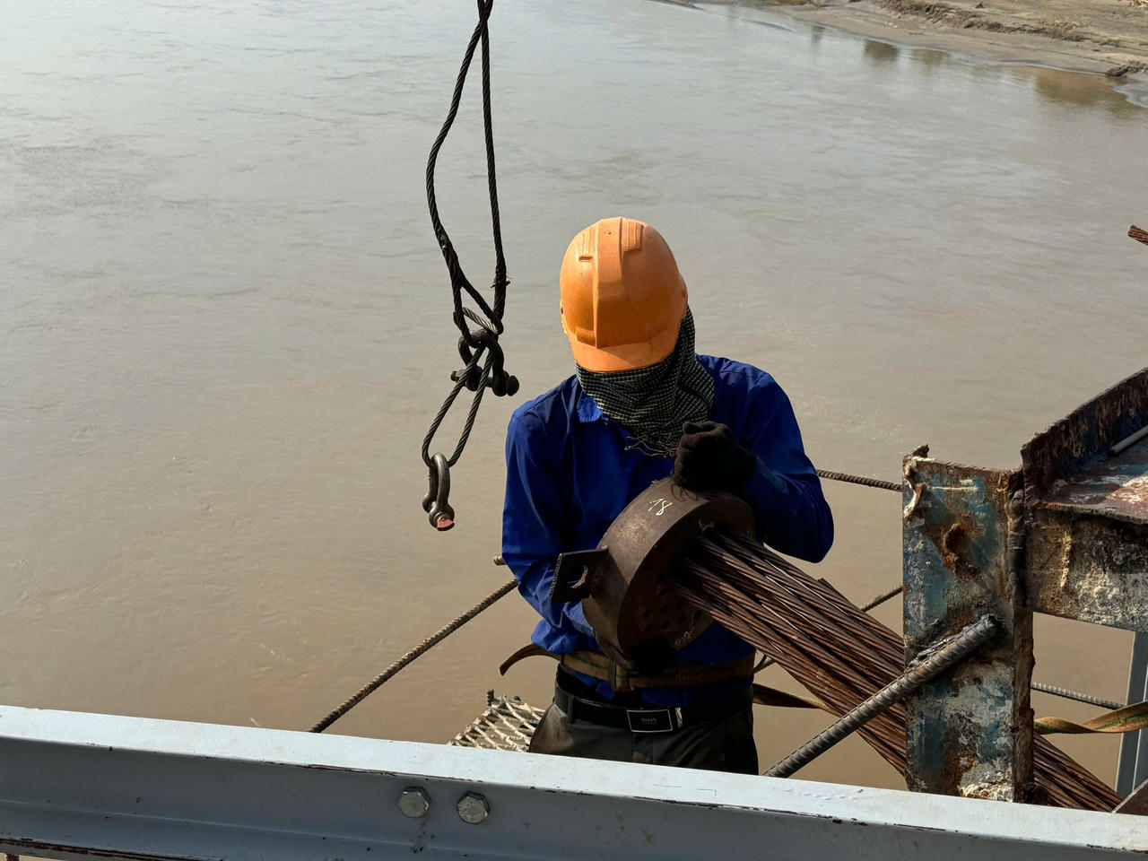 Sau mưa lũ, công nhân, kỹ sư dự án cầu Phú Thịnh tập trung kéo cáp cầu dây văng