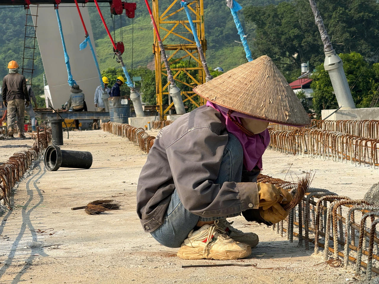 Sau mưa lũ, công nhân, kỹ sư dự án cầu Phú Thịnh tập trung kéo cáp cầu dây văng