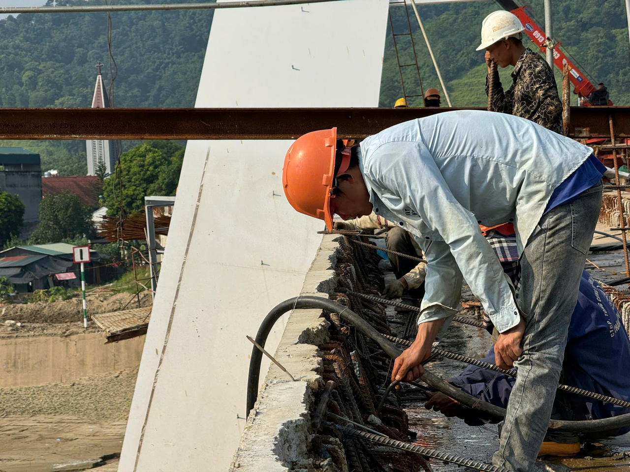 Sau mưa lũ, công nhân, kỹ sư dự án cầu Phú Thịnh tập trung kéo cáp cầu dây văng