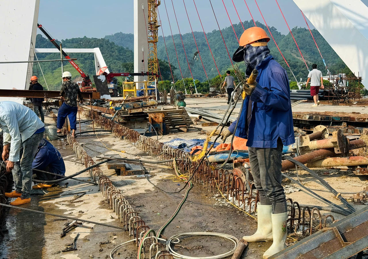 Sau mưa lũ, công nhân, kỹ sư dự án cầu Phú Thịnh tập trung kéo cáp cầu dây văng