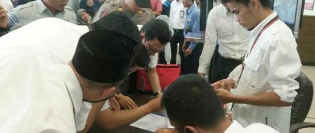  Quan chức Lion Air kiểm tra danh sách hàng khách trên chuyến bay JT610 tại Sân bay Depati Amir. (Ảnh: Reuters)