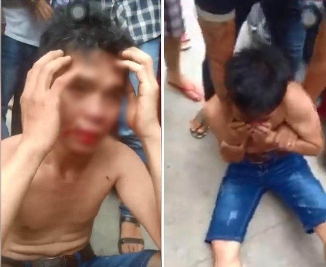 Bị đám đông hành hung và liên tục chất vấn, người đàn ông chỉ biết ngồi im, lấy tay che mặt.&nbsp;(Ảnh cắt từ clip).