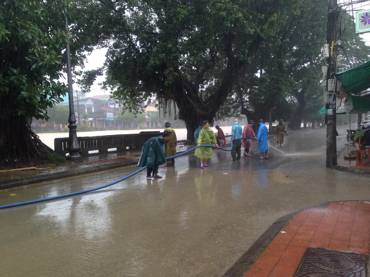 Công an Huế xắn quần áo đội mưa dọn bùn thông đường cho người dân đi