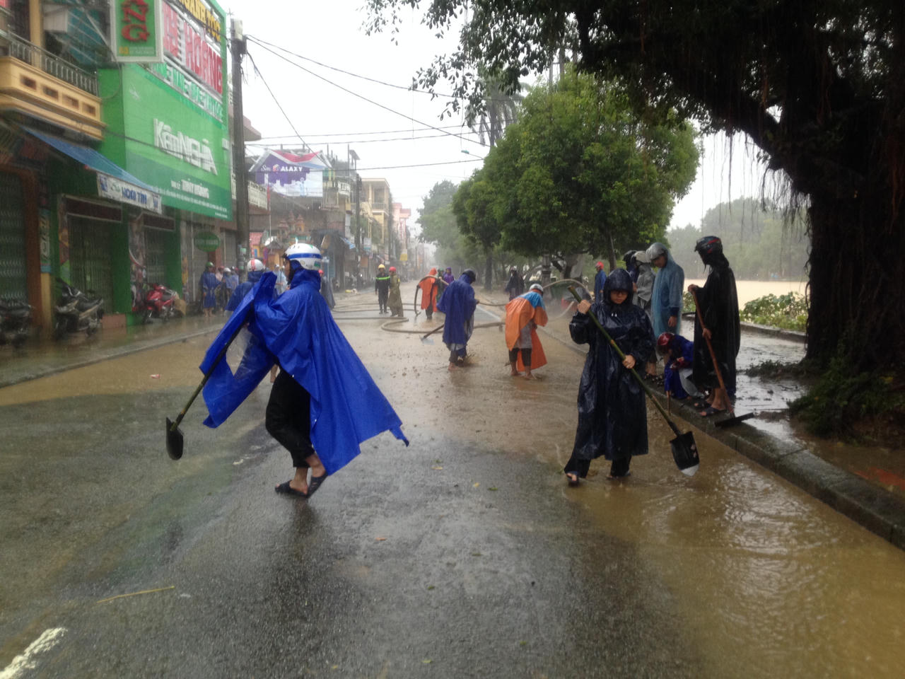 Công an Huế xắn quần áo đội mưa dọn bùn thông đường cho người dân đi