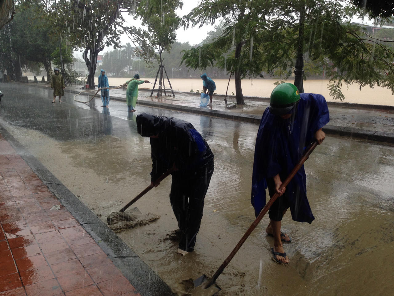 Công an Huế xắn quần áo đội mưa dọn bùn thông đường cho người dân đi