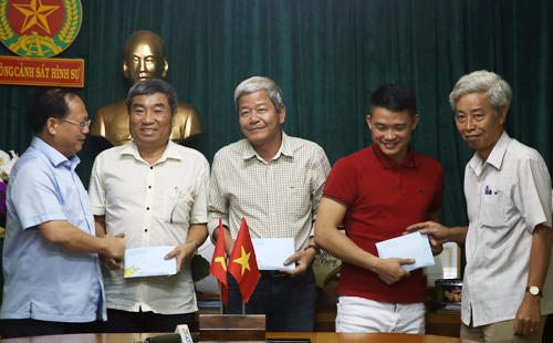 Ông Tất Thành Cang (bên trái) khen thưởng lực lượng công an tham gia phá án. Ảnh: Quốc Thắng.