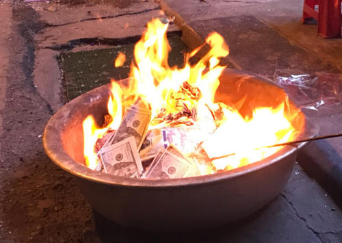 Người dân đốt tiềnvàng mã vào đêm 30 Tết Nguyên đán tại phố Mã Mây, Hoàn Kiếm, Hà Nội. Ảnh: Giang Huy.