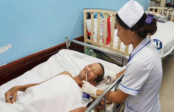 Bệnh nhân được chăm sóc suốt 3 tháng qua vì không thể làm thủ tục xuất viện dù bệnh đã ổn. Ảnh: Lê Phương.