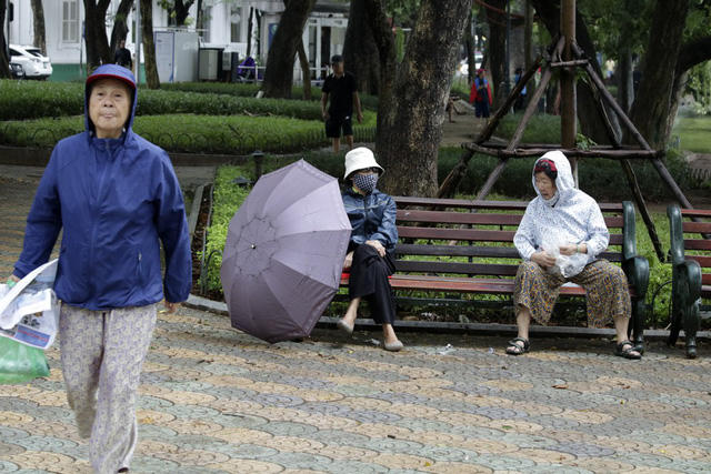 Người già ra đường trong trang phục ấm áp.