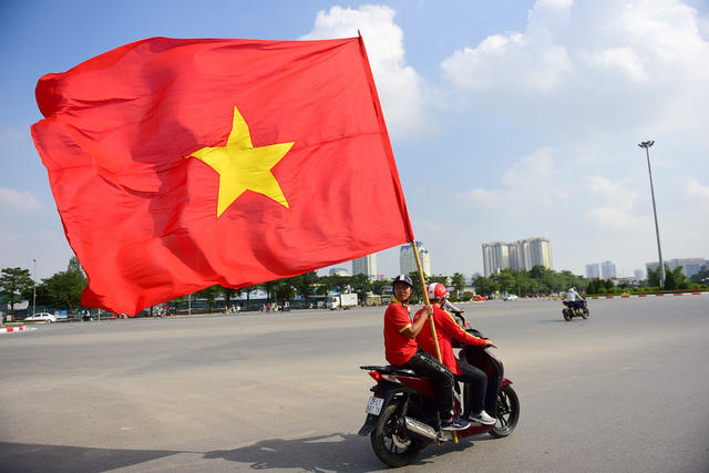 Một cổ động viên lâu năm là người cầm cờ và giữ nhịp cổ động trên đường phố.