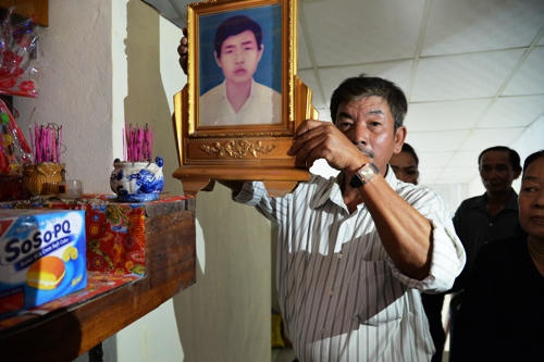 Ông Bình dỡ bỏ bàn thờ của em trai sau ngày đoàn tụ. Ảnh: Phương Linh.