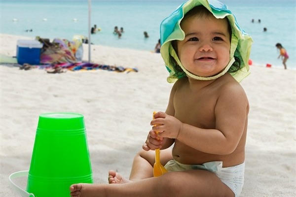 Cho trẻ đi du lịch ngày nắng nóng lưu ý che chắn da bé.