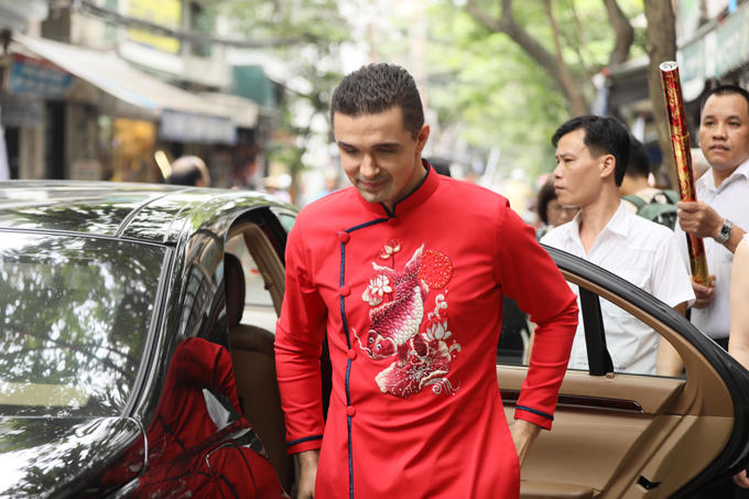 Khoảng 10h, chú rể Marcin cùng bố mẹ xuất hiện trước cửa nhà cô dâu ở khu phố cổ Hà Nội. Anh cũng mặc áo dài đỏ với hình ảnh cá chép giống như vợ. Đây là lần đầu tiên anh diện trang phục truyền thống của người Việt.