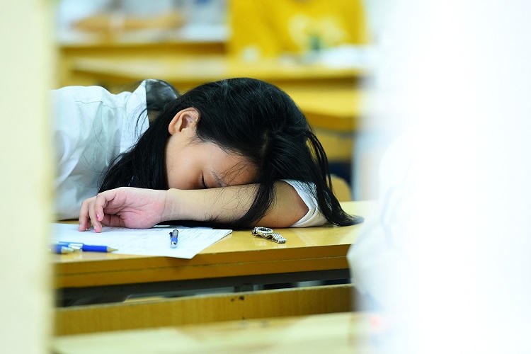 Một thí sinh ngủ gục trên bàn trước giờ thi môn Toán vào lớp 10 ở Hà Nội hôm 2/6. Ảnh: Giang Huy