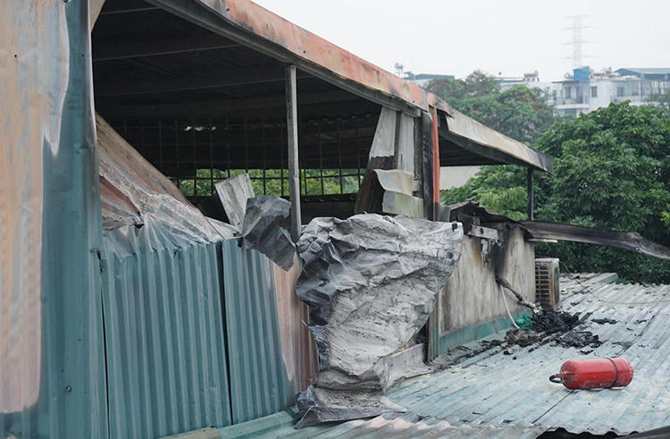 Căn nhà bốc cháy quây kín bằng tấm tôn. Ảnh: Nguyễn Định.