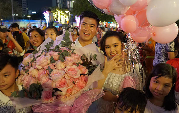 Duy Mạnh và bạn gái Quỳnh Anh chụp ảnh cùng người hâm mộ sau màn cầu hôn tại phố đi bộ Nguyễn Huệ, TP HCM.