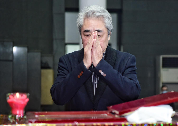 NSND Quang Thọ lặng người bên linh cữu Vũ Mạnh Dũng. Ảnh: Giang Huy.