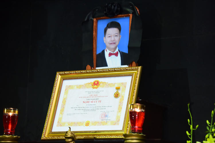 Ca sĩ Vũ Mạnh Dũng nhận danh hiệu Nghệ sĩ Ưu tú tháng 9 năm ngoái. Tấm bằng được người thân đặt trước di ảnh anh trong lễ tang. Ảnh: Giang Huy.