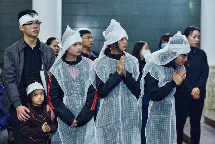 Chị Hoàng Yến (phải) - vợ nghệ sĩ - giữ bình tĩnh, cùng các con và người nhà lo hậu sự cho chồng. Ảnh: Giang Huy.