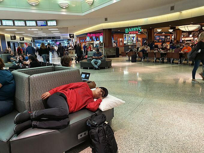 Tuấn Hưng mang giày và nằm ngủ chợp mắt tại sân bay Mỹ.