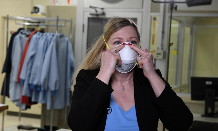 Tiến sĩ Nicole McCullough, chuyên gia y tế và sức khỏe toàn cầu của công ty 3M, hướng dẫn cách đeo khẩu trang N95 đúng cách trong phòng thí nghiệm công ty hôm 4/3. Ảnh: Reuters.
