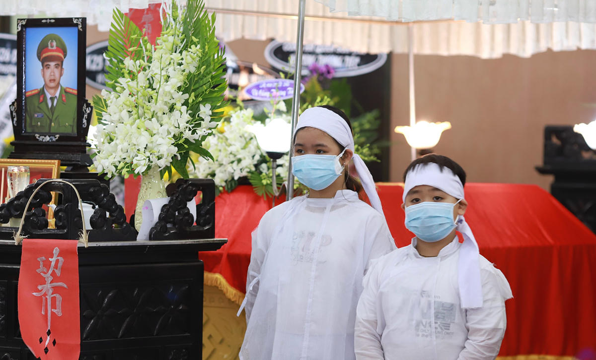 Hai con của thiếu tá Đặng Thanh Tuấn bên linh cữu cha, tại nhà tang lễ thành phố chiều 3/4. Ảnh: Nguyễn Đông.