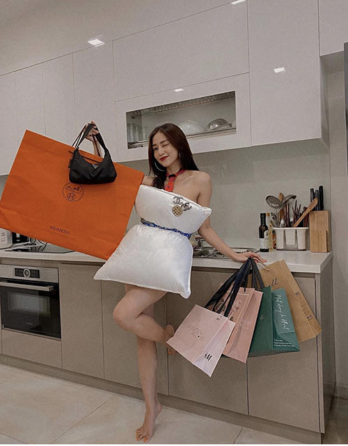 Salim khoe vóc dáng mảnh mai trong gian bếp với túi kẹp nách và loạt túi giấy tựa như đang đi mua sắm.