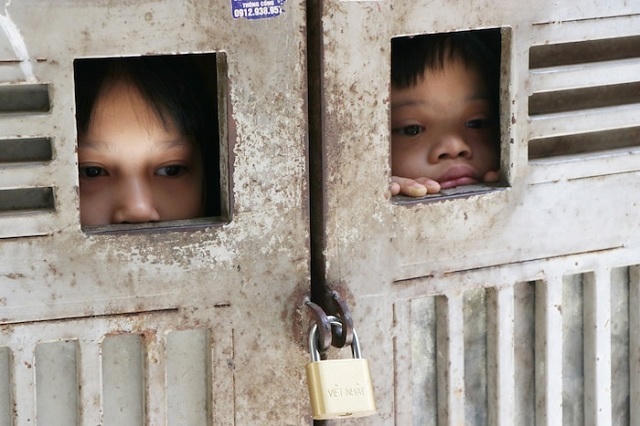 Cánh cửa sắt đóng kín, ngăn ba đứa trẻ với thế giới bên ngoài. Ảnh: Nguyễn Ngoan