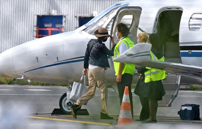 Nicole theo sau Brad Pitt, đeo khẩu trang và đội mũ kín mít.