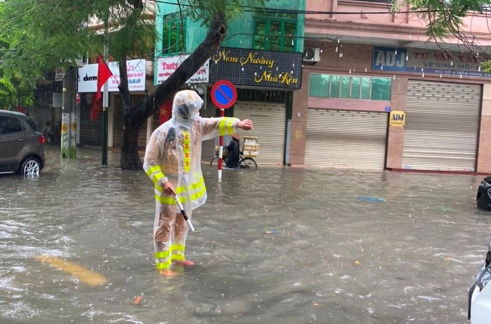 100 cảnh sát đội mưa lội nước giúp người dân Hải Phòng vượt đường ngập lụt