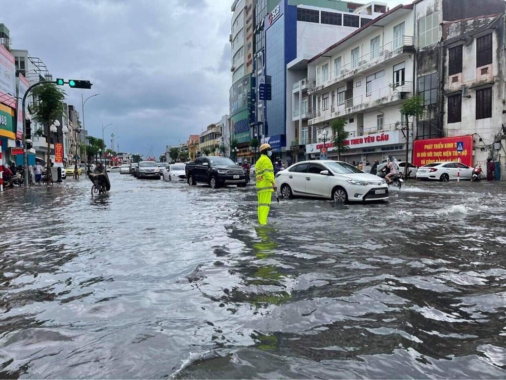 100 cảnh sát đội mưa lội nước giúp người dân Hải Phòng vượt đường ngập lụt