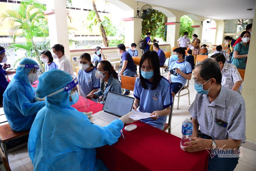 Cảnh phụ huynh theo con đi tiêm vaccine COVID-19 ở TP HCM