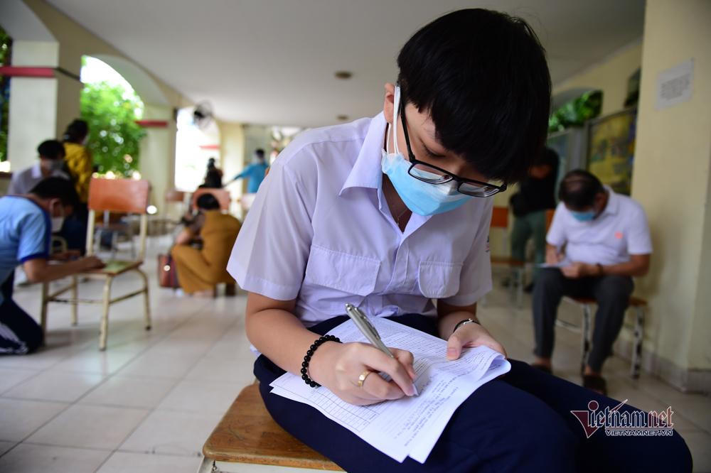 Cảnh phụ huynh theo con đi tiêm vaccine COVID-19 ở TP HCM