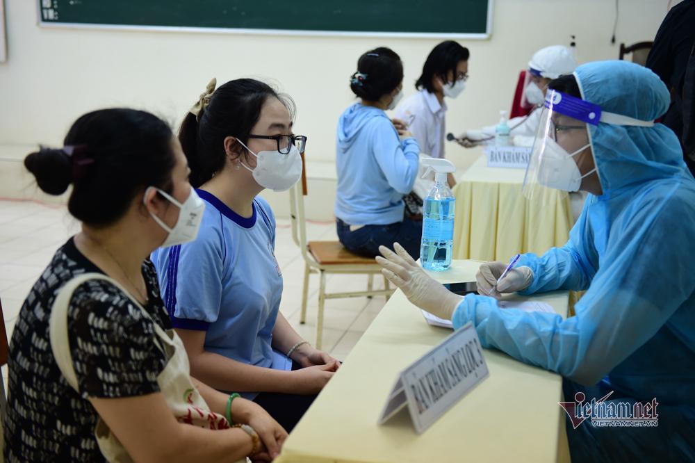 Cảnh phụ huynh theo con đi tiêm vaccine COVID-19 ở TP HCM