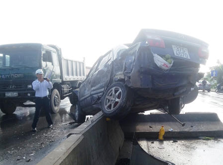 Xe tải hất xe con vào cột đèn giao thông, trèo dải phân cách